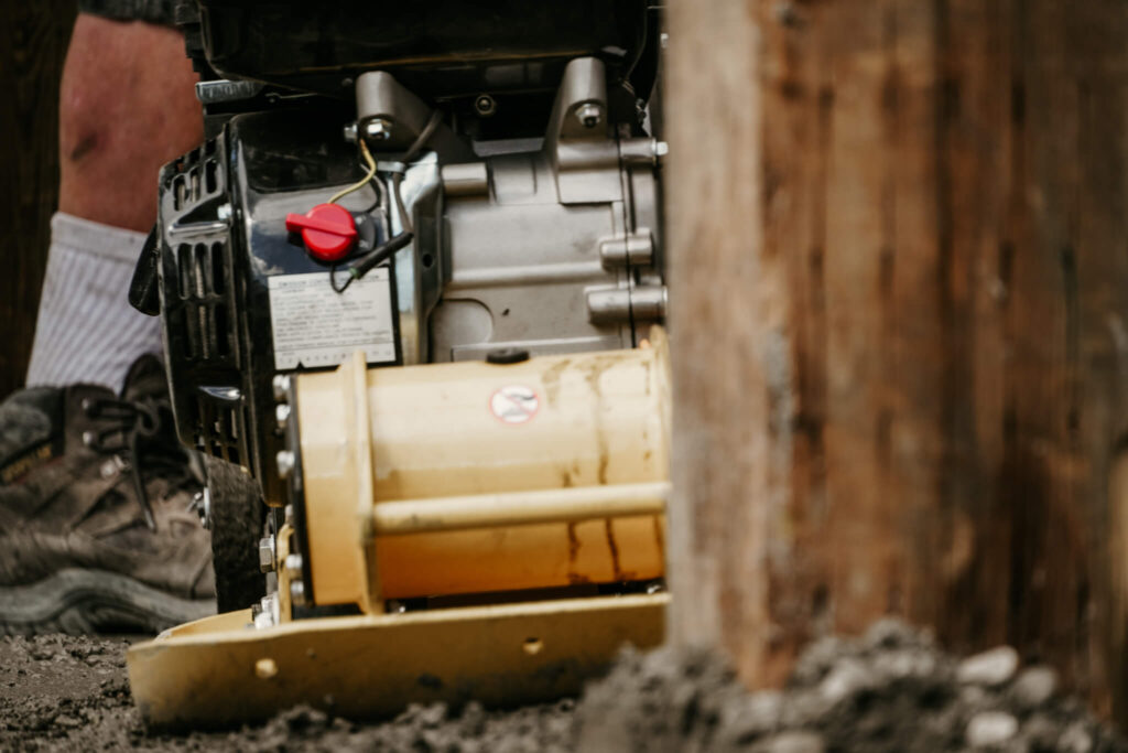 Close-up of a piece of machinery on an Earth and Turf Landscaping Edmonton retaining wall job site.