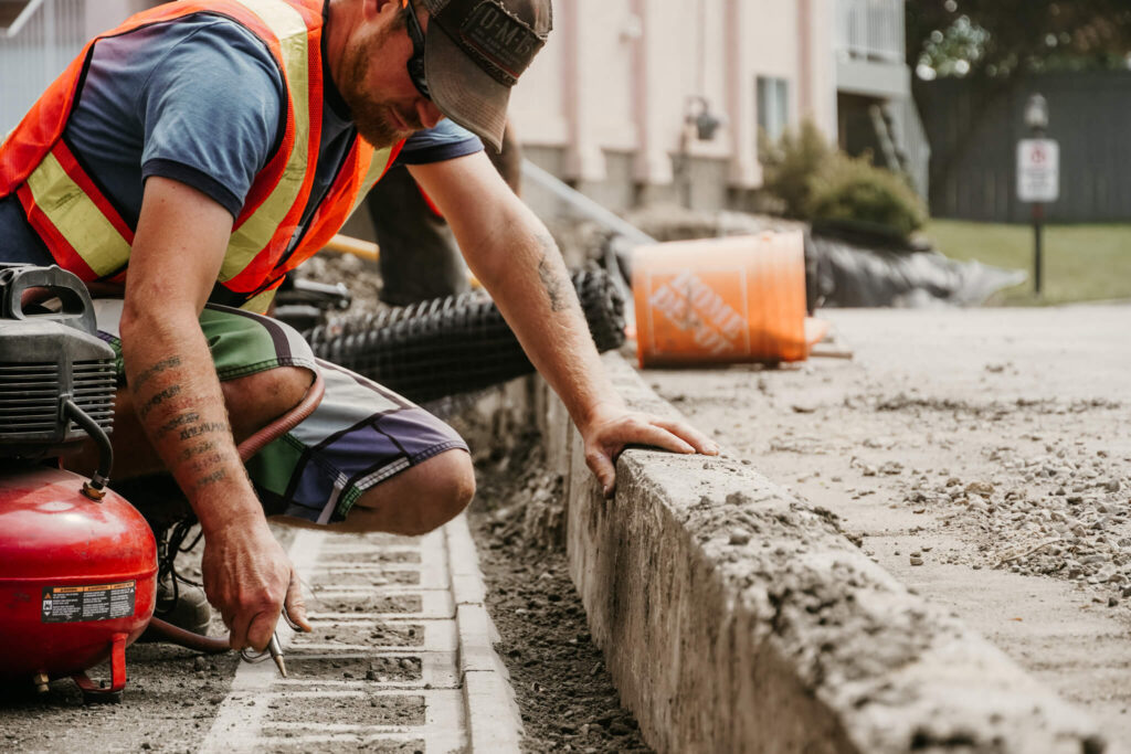 An Earth and Turf Landscaping Edmonton worker detailing a retaining wall.