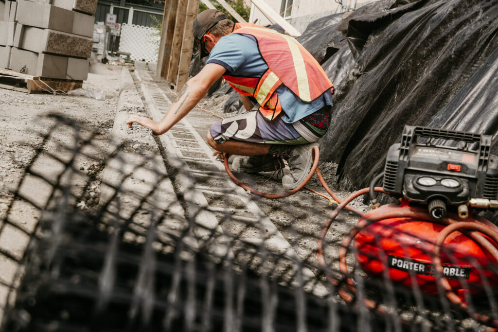 An Earth and Turf Landscaping Edmonton worker doing detailing on a retaining wall project.